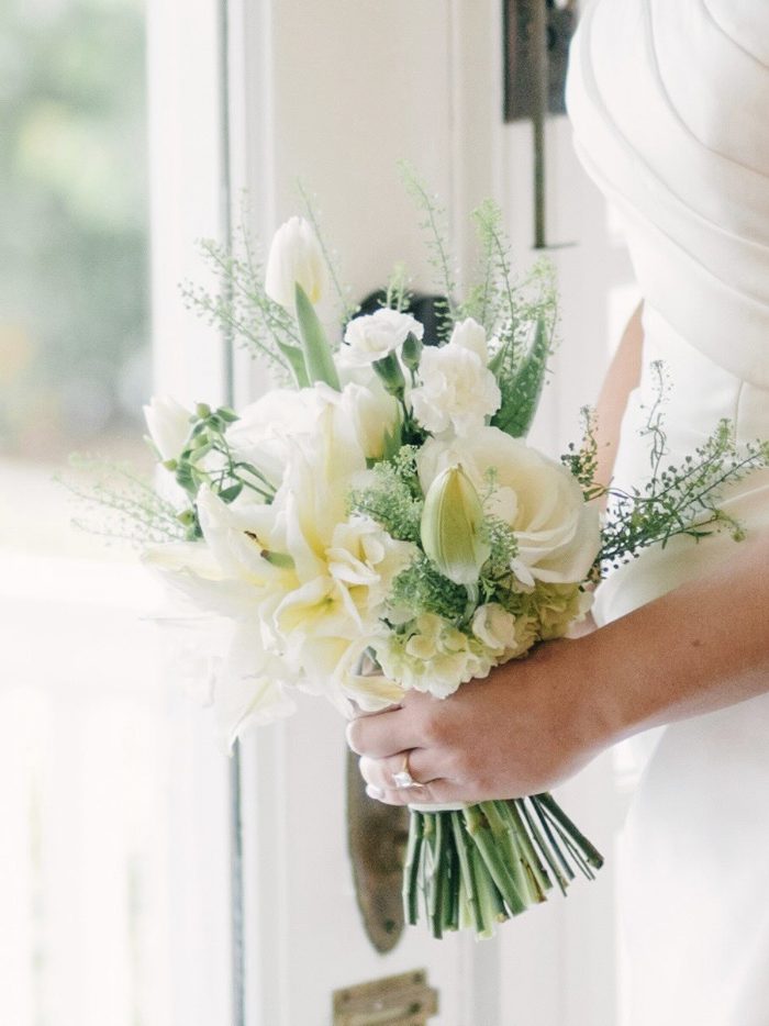 Bride holding an ivory and green bridal bouquet