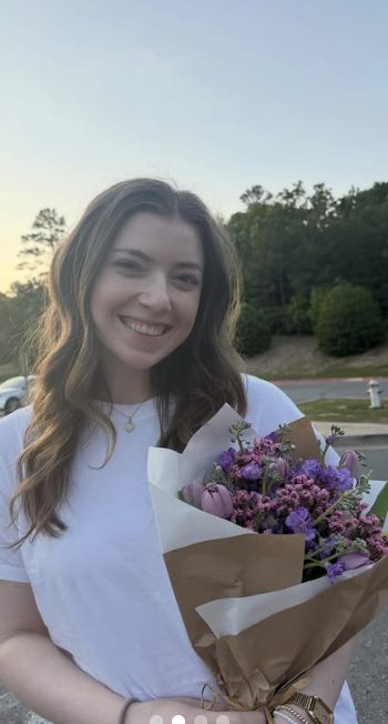 Customer holding a lavender and tulip wrapped bouquet